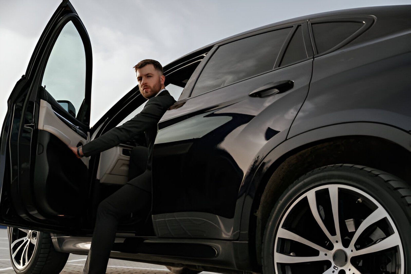 a businessman coming out of a black car